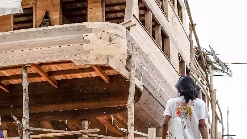 Multi-deck wooden liveaboard hull under construction, deck levels framed and planked