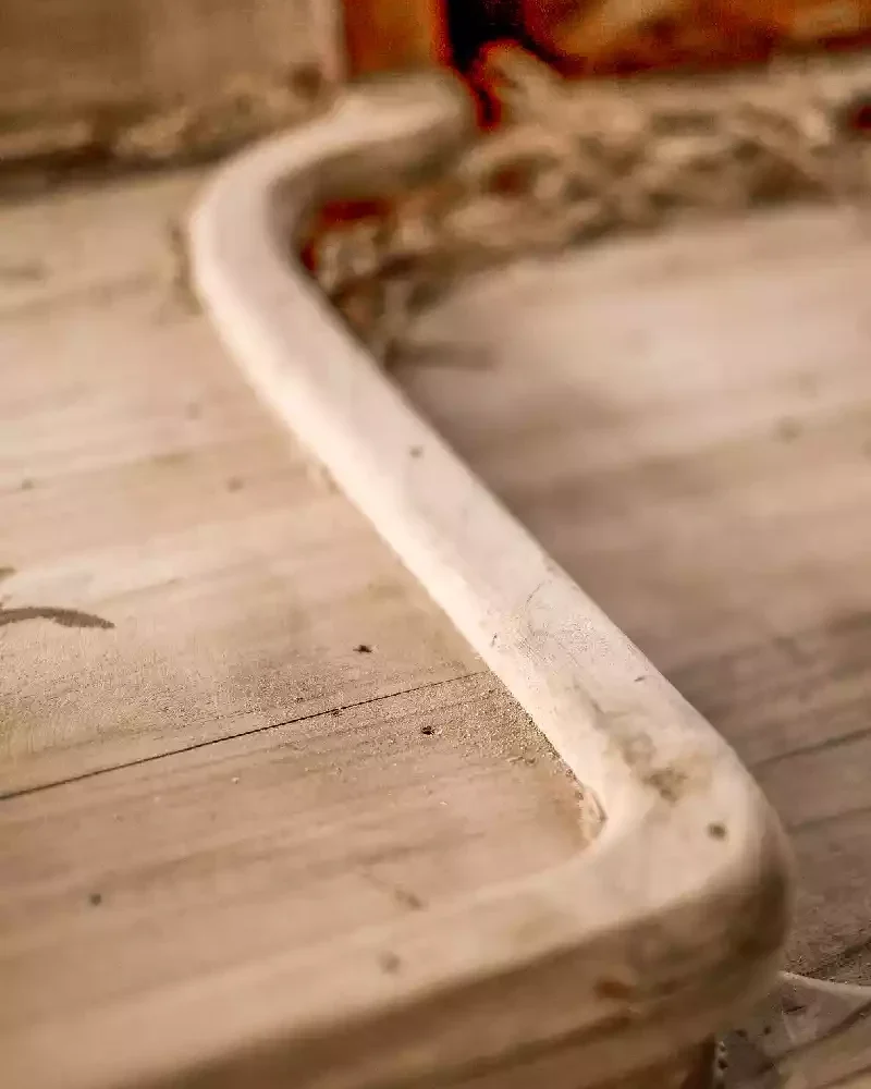 Close-up of a timber member shaped to a long fair curve on a hull under construction